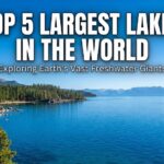 Alt Text: A blog feature image with a large white title "TOP 5 LARGEST LAKES IN THE WORLD" and subtitle "Exploring Earth's Vast Freshwater Giants" overlaid on a scenic photograph of a wide, blue lake surrounded by pine forests, rocky shores, and distant mountains under a clear blue sky.